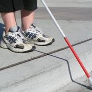 Los pies de una persona ciega guiada por el bastón.